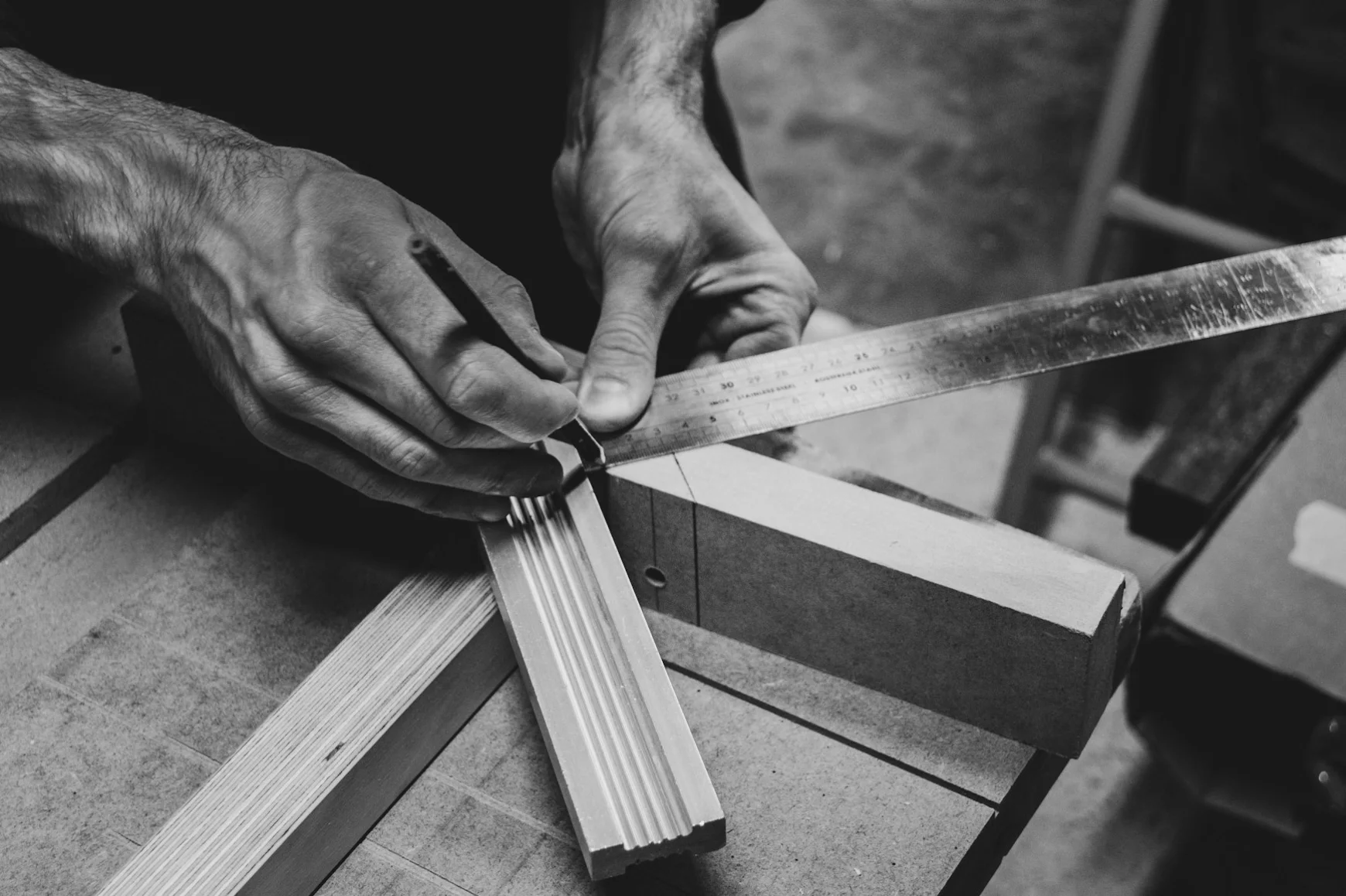 Artigiano misura un profilo in legno in officina