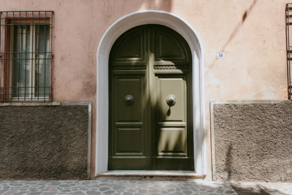 Portone d’ingresso in legno con arco su facciata storica